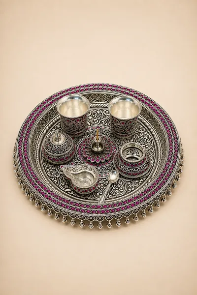 Pierced sterling silver pooja set with pink stonework and a lotus medallion, handcrafted in Jaipur.