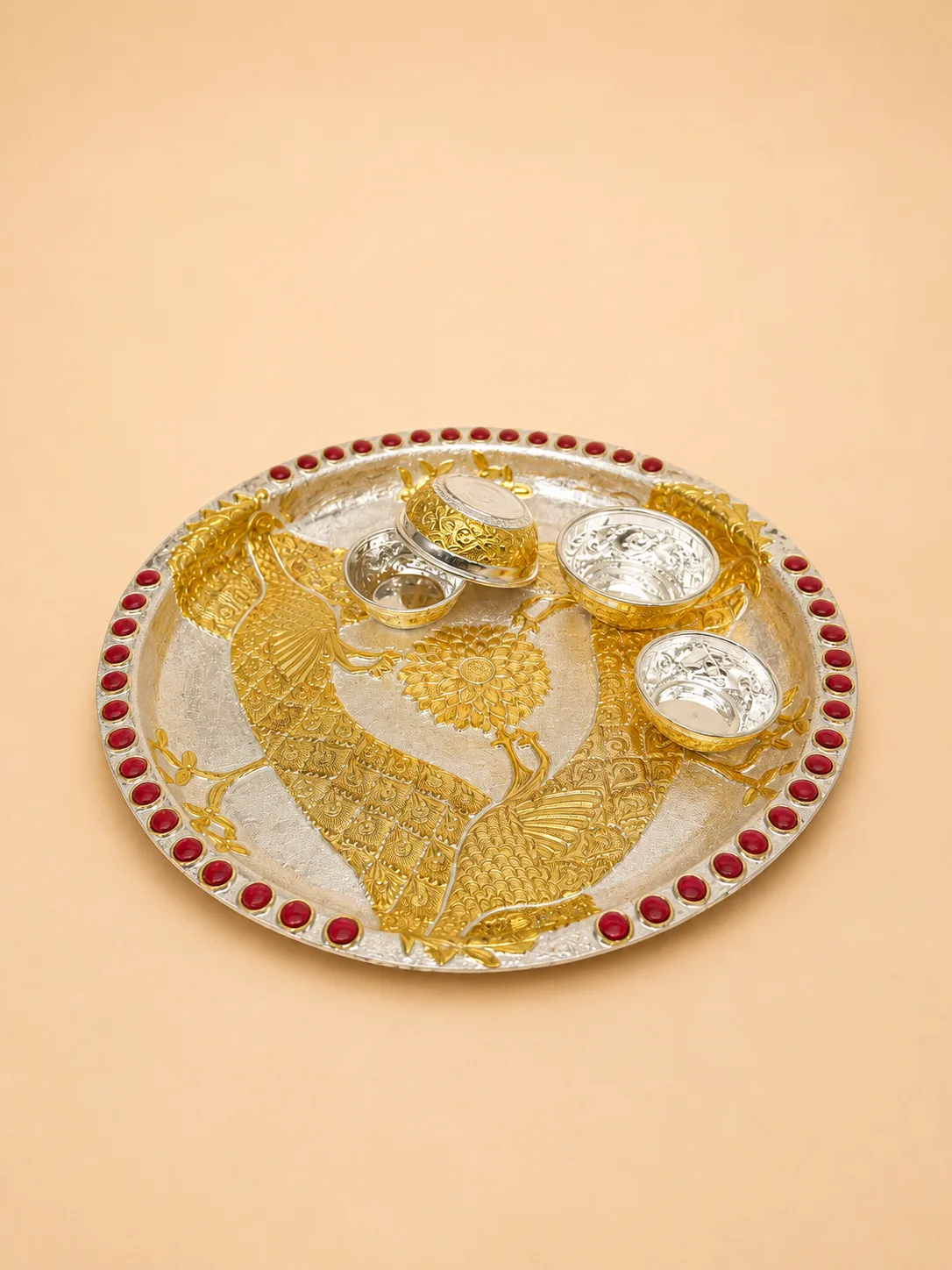 Sterling silver pooja thali with facing gold peacocks, a central lotus, and matching bowls, handcrafted in Jaipur.