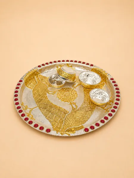 Sterling silver pooja thali with facing gold peacocks, a central lotus, and matching bowls, handcrafted in Jaipur.