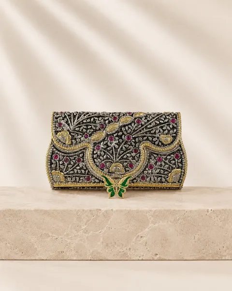Relief-carved sterling silver clutch with an enamel butterfly, handcrafted in Jaipur.