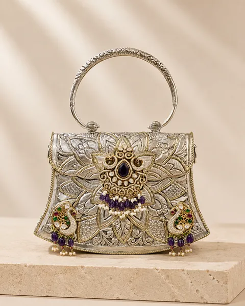 Relief-carved sterling silver handle bag with a lotus motif, handcrafted in Jaipur.
